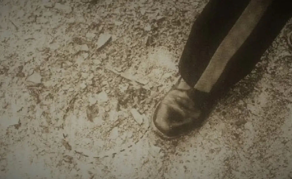Impronta gigante accanto a scarpa di poliziotto